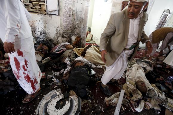 People look for survivors at the scene of a suicide bombing inside a mosque in Sanaa