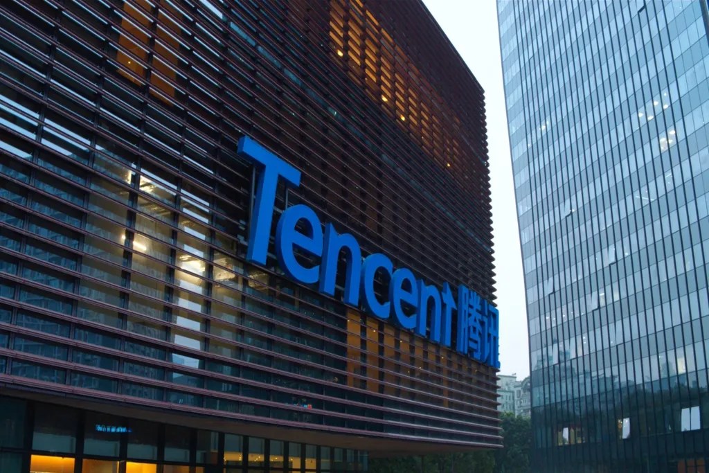 Façade en verre du siège social de l'entreprise Tencent avec son logo bleu