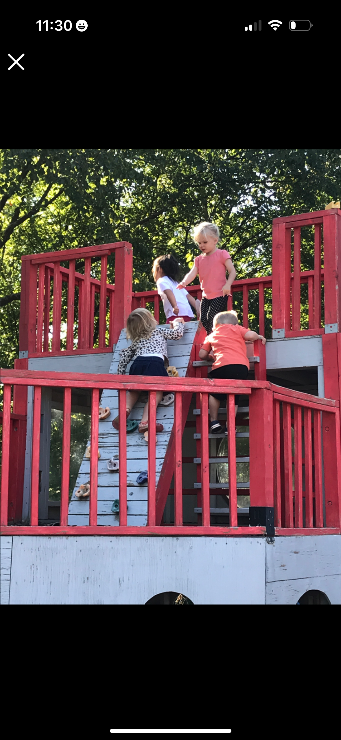 four children playing and climbing on outdoor play structure