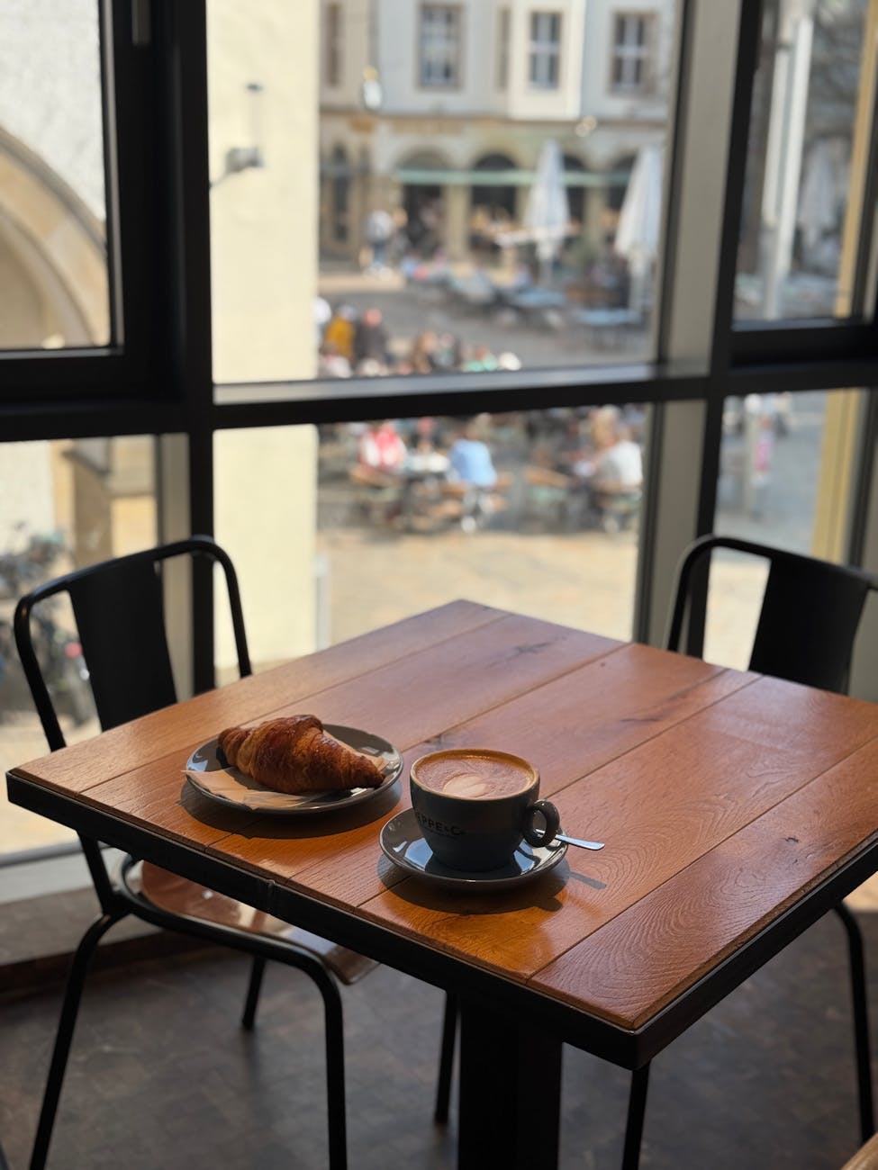 cozy cafe table with croissant and coffee