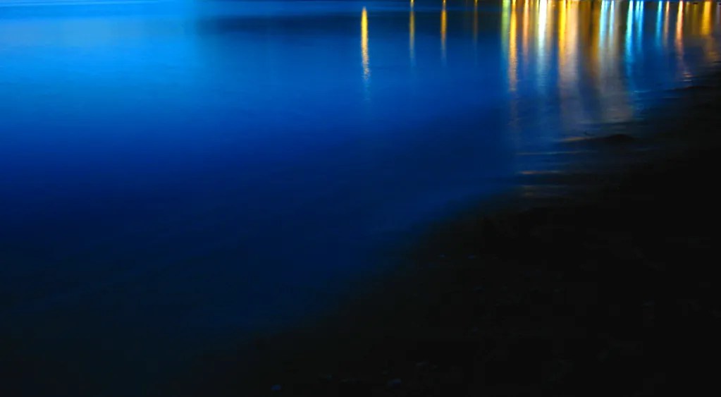 Time exposure of Vancouver, BC's English Bay shoreline at night, with traffic light reflections.