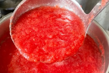 a ladle full of pasta over a saucepan