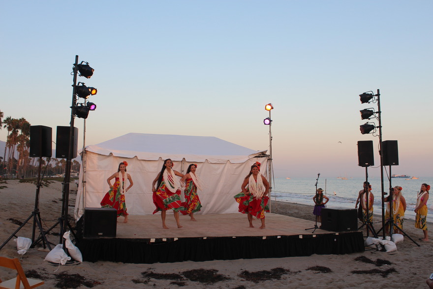 Dancers on a beach stage at sunset