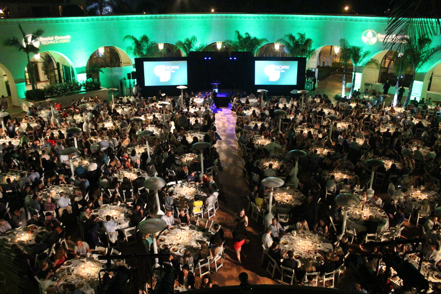 Banquet tables under green palm lighting