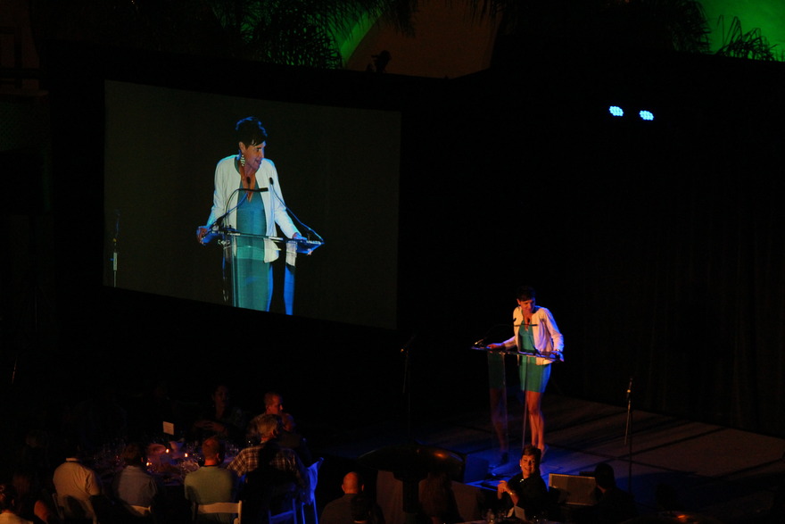Performer beside a large projection screen
