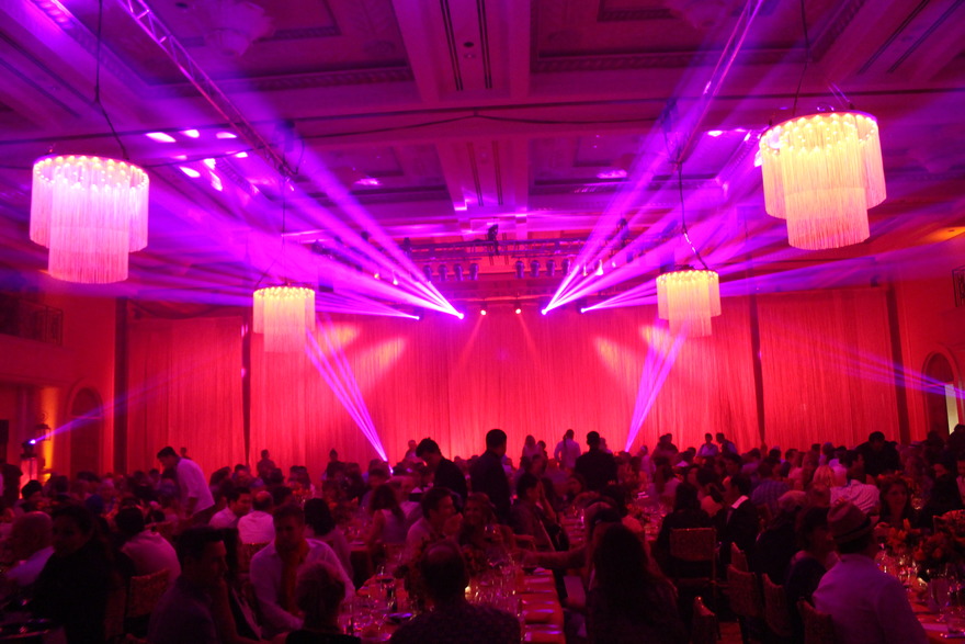 Magenta beams over a ballroom reception