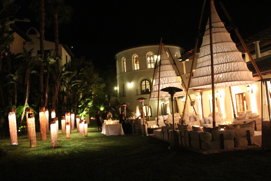 Lit lanterns on lawn beside a resort