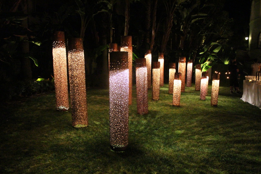 Illuminated cylindrical lanterns among the trees