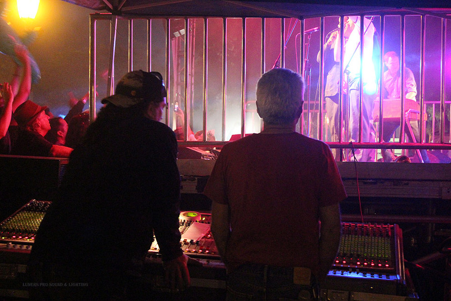 Lighting technicians silhouetted at the console
