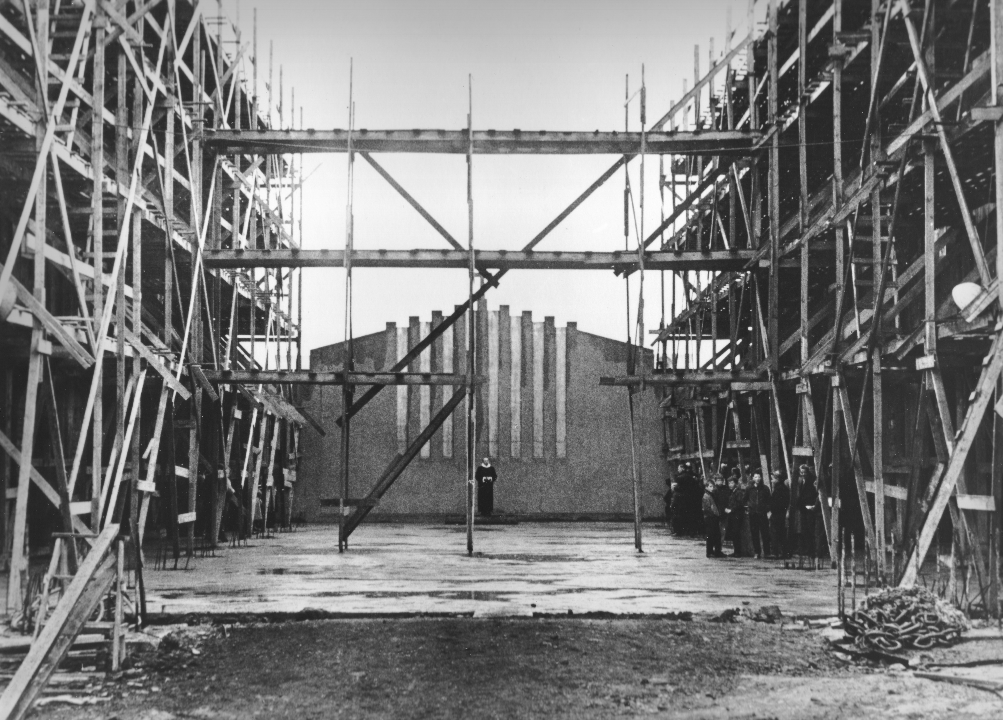 Masses were held in the unfinished church building from 1948 on. Here, an early mass is held under the open sky.