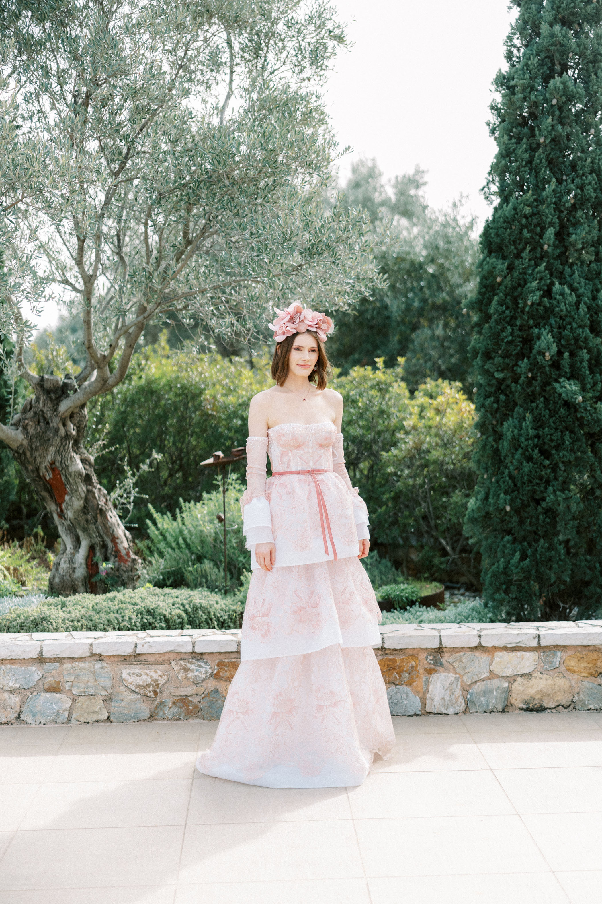 bride in a blush pink wedding dress with pink floral hairpiece