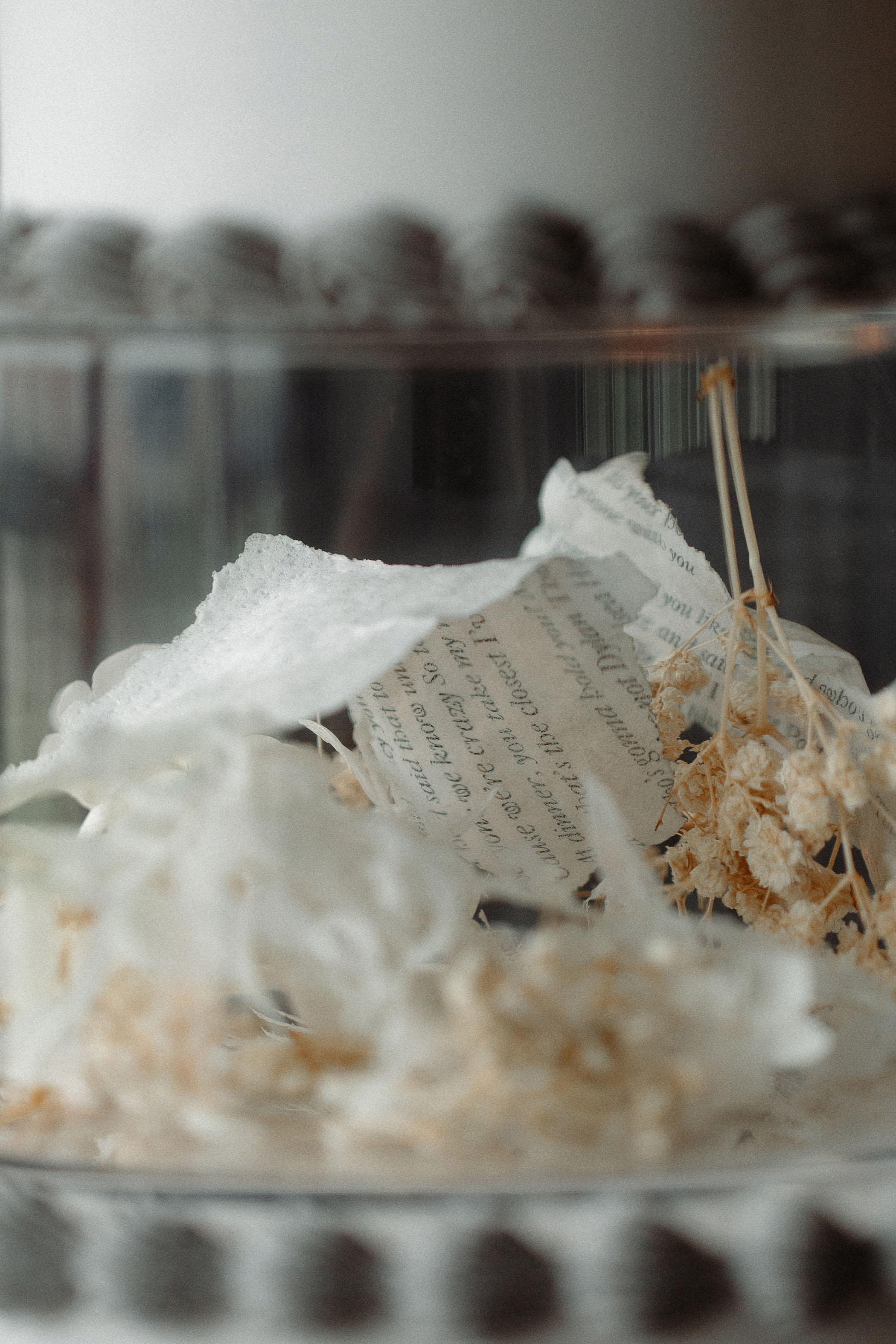 words of poetry on thin sheets of paper placed inside a transparent tier on a wedding cake