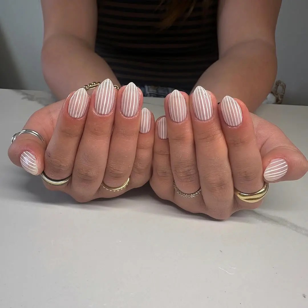 sheer almond shaped manicure with striped white nail designs