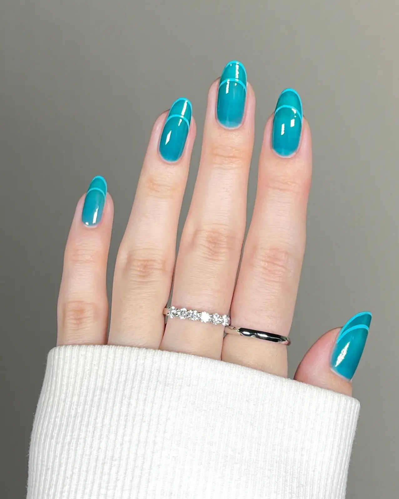 Long almond sheer teal jelly nails with a glossy finish and negative space base