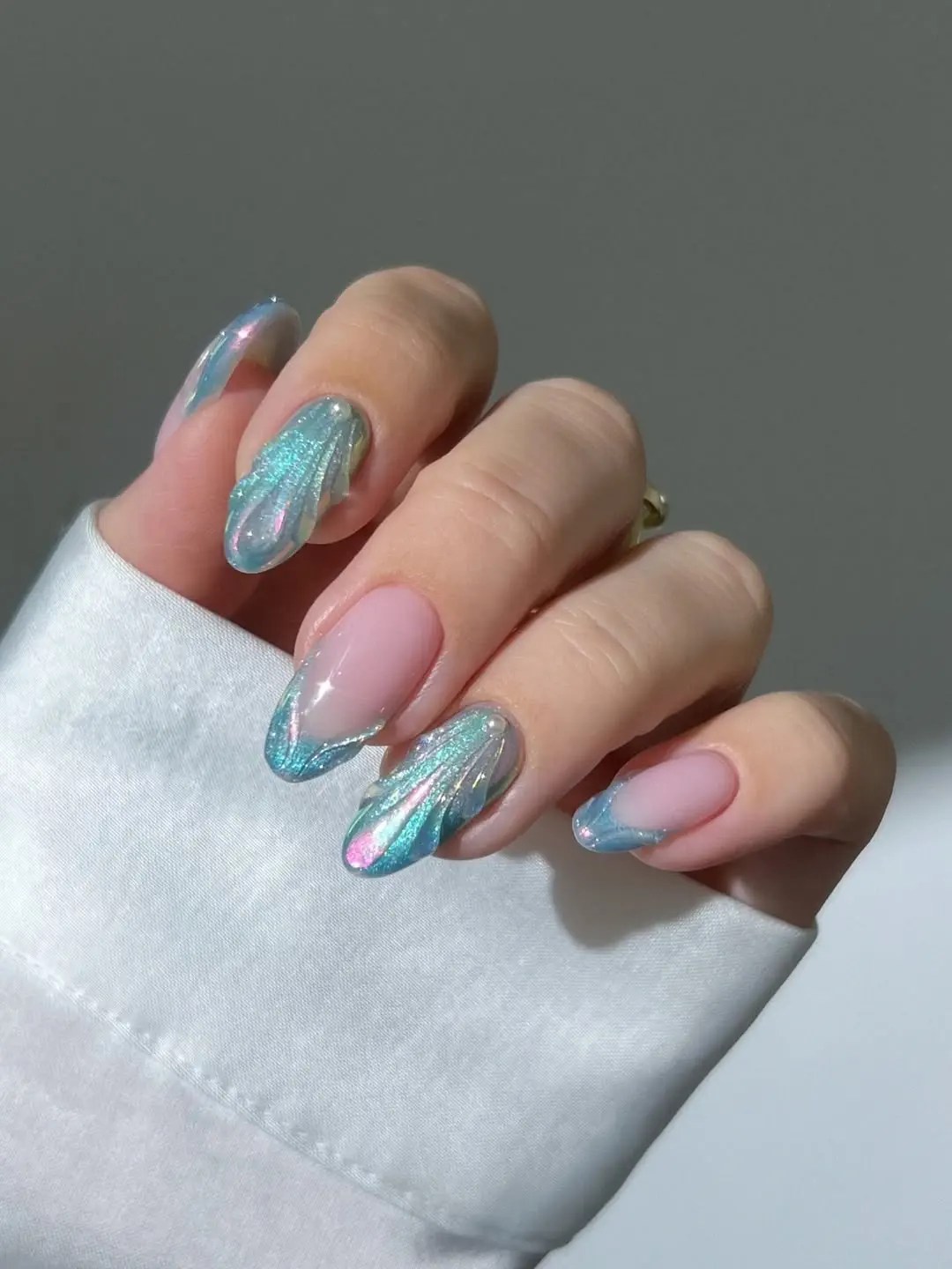 Mermaid French tip nails with sculpted aqua chrome shell tips, a pink flash, and single pearl accents