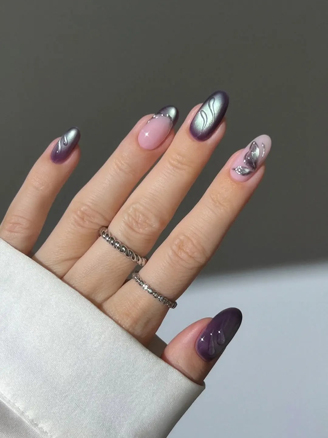 Plum cat eye Summerween nails with liquid silver swirls and a sheer chrome butterfly accent