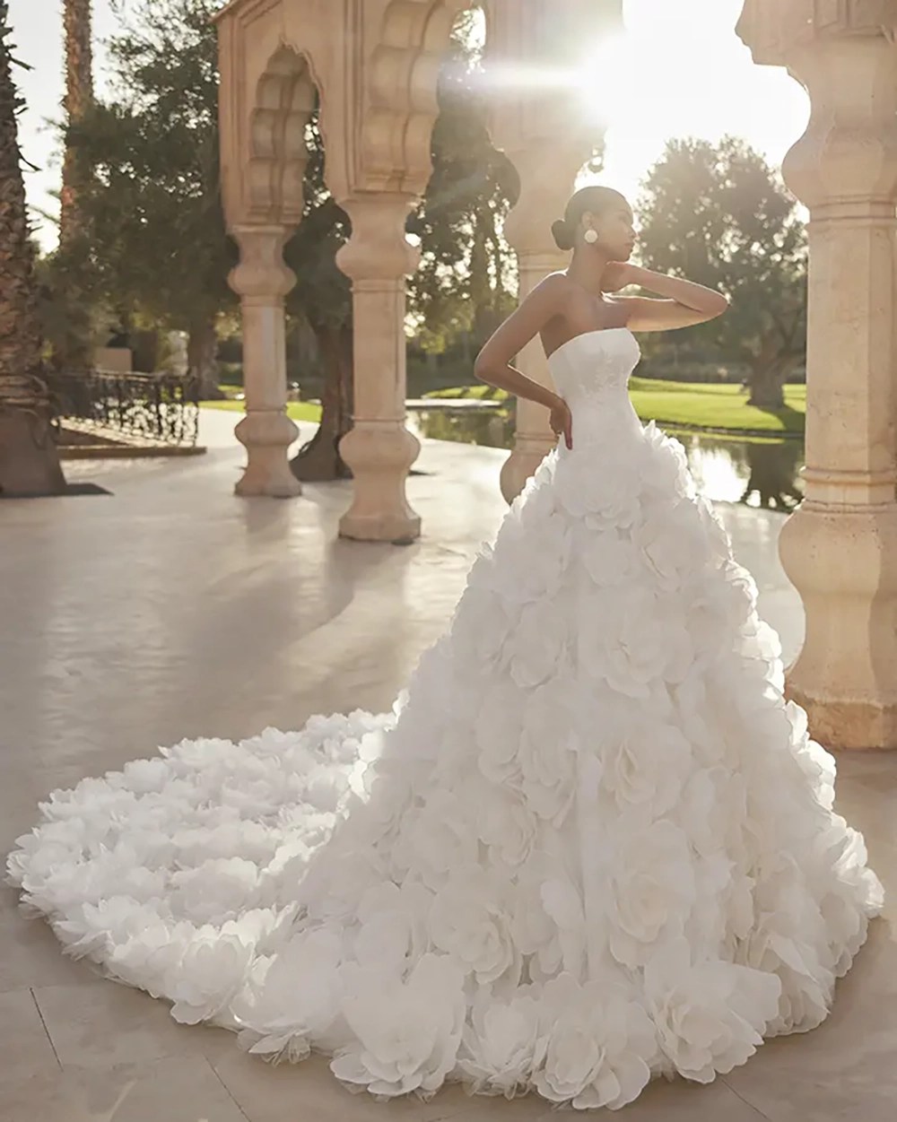 Rosa Clará ORESTE strapless wedding dress with a skirt and cathedral train covered in oversized 3D organza flowers