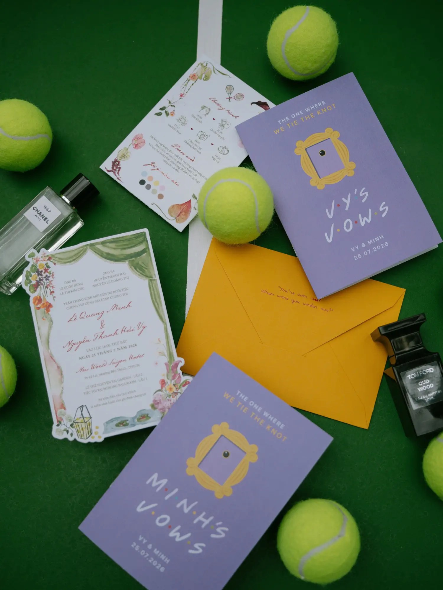 Friends-themed lavender wedding vow booklets reading The One Where We Tie the Knot with a die-cut watercolor Vietnamese invitation and tennis balls on a green court flat lay