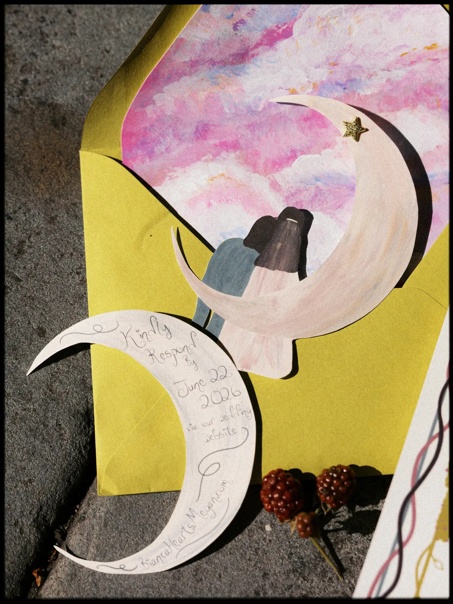 Crescent moon RSVP card illustrated with two figures sitting on the moon, resting on a mustard envelope lined with painted pink and lavender clouds