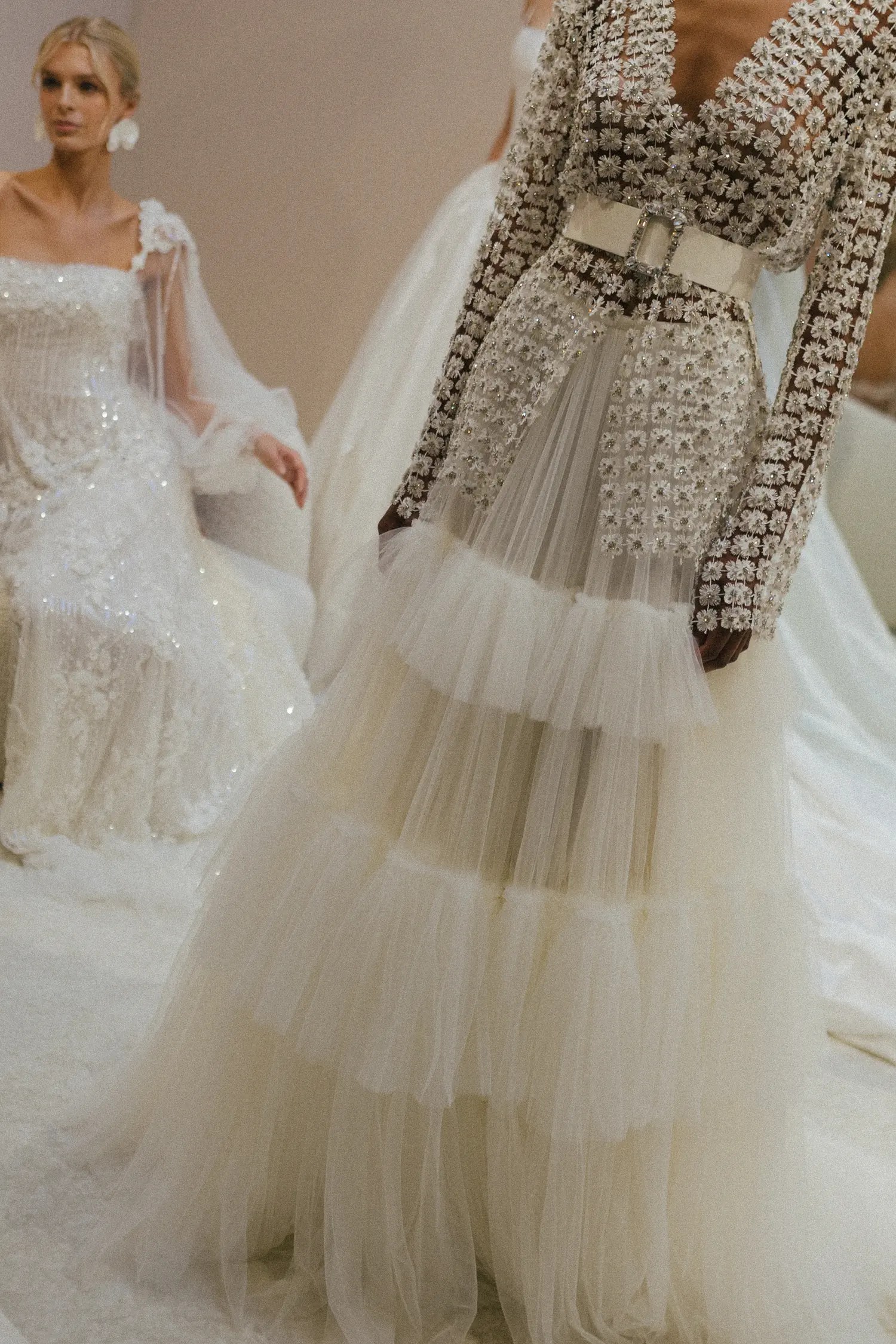 Lihi Hod Rise and Shine bridal look with an embellished long-sleeve open jacket cinched with a wide belt over a multi-tiered tulle skirt