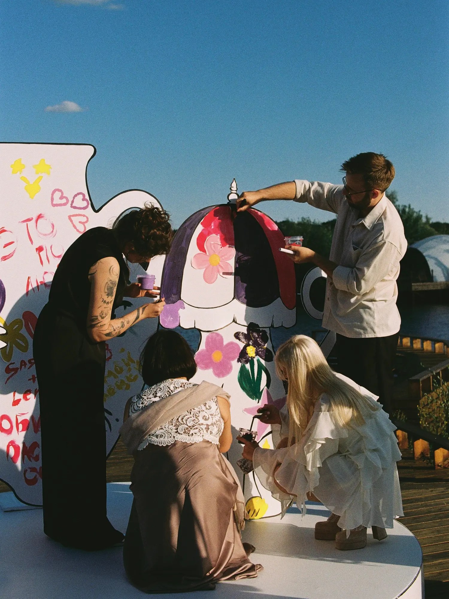 guests painting wedding backdrop