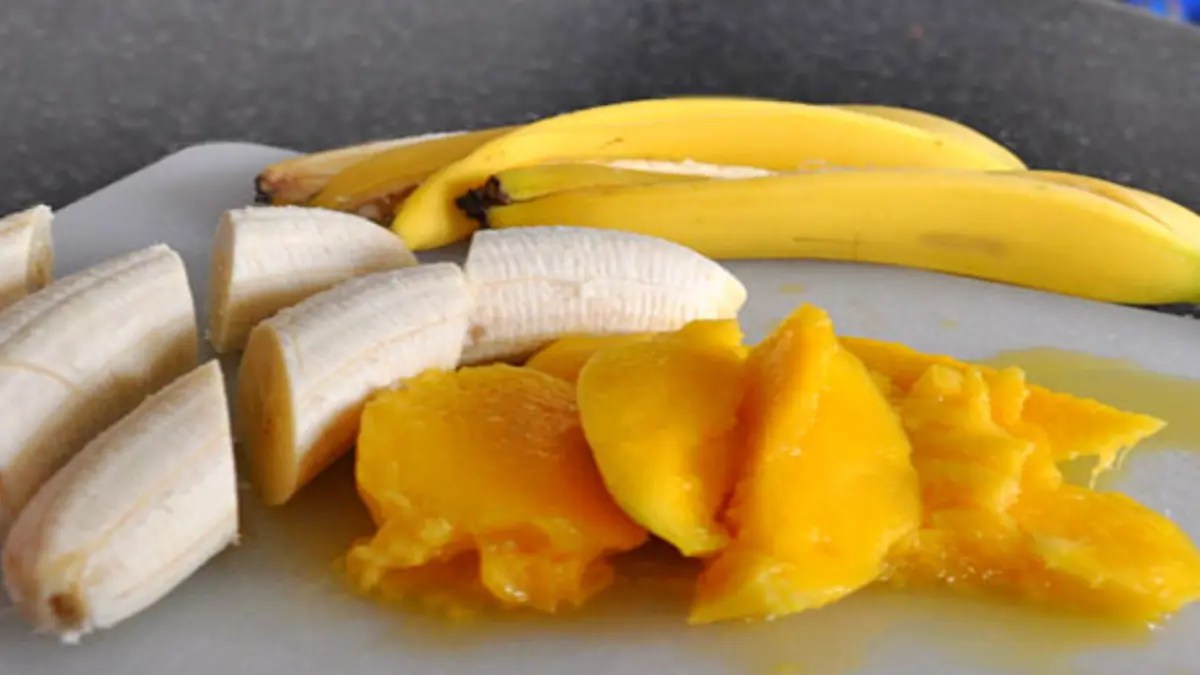 Sliced banana and ripe mango pieces arranged on a plate.