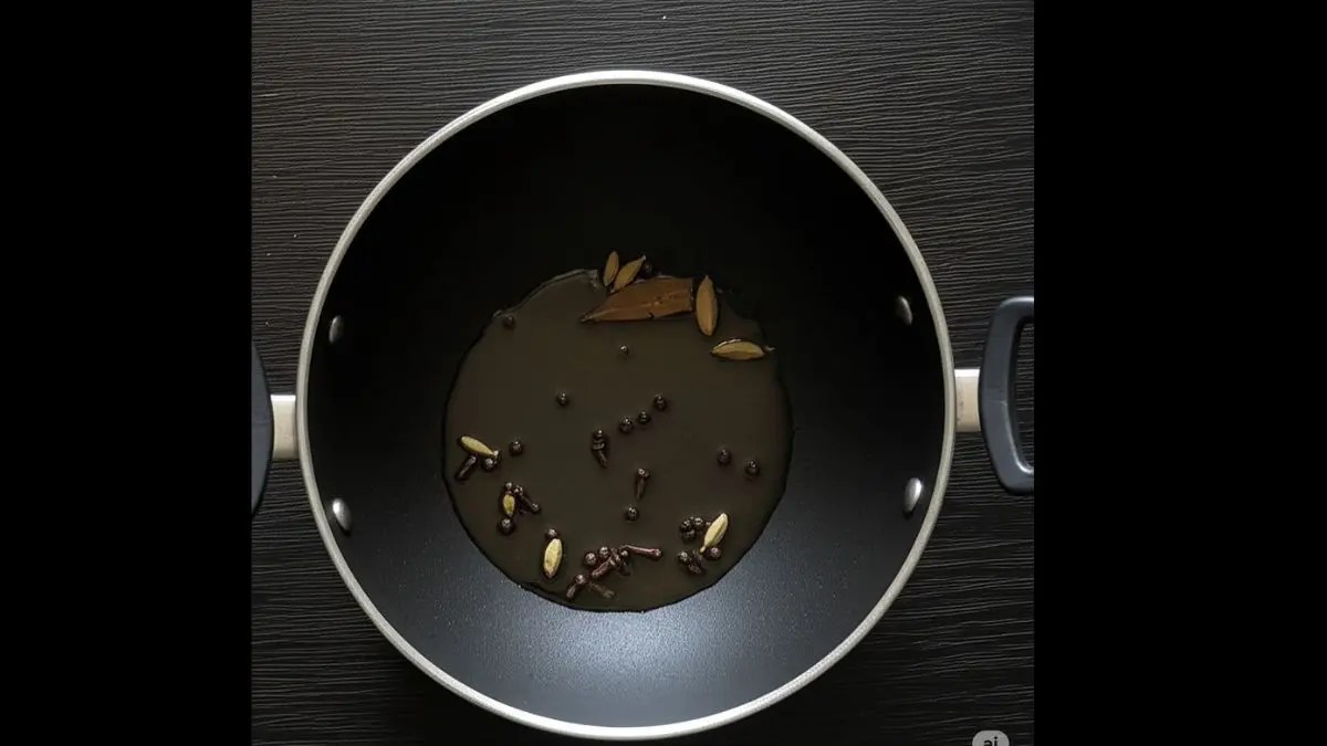 Spices including bay leaf, cloves, black peppercorns, green cardamom, black cardamom, and a cinnamon stick sizzling in hot oil or ghee in a heavy pan.