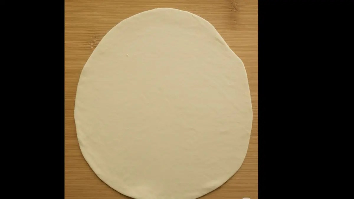 Take one dough ball and roll it out thin on a flat surface using a little dry flour to prevent sticking.