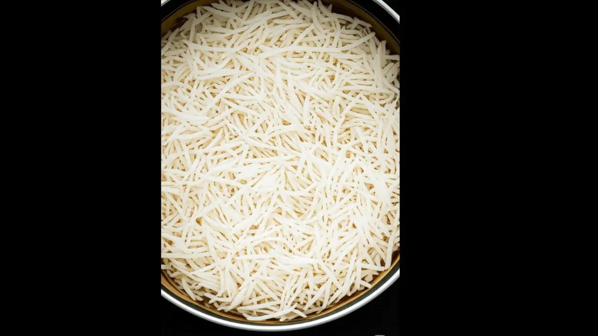 The remaining cooked rice spread evenly as the second layer over the biryani mixture.