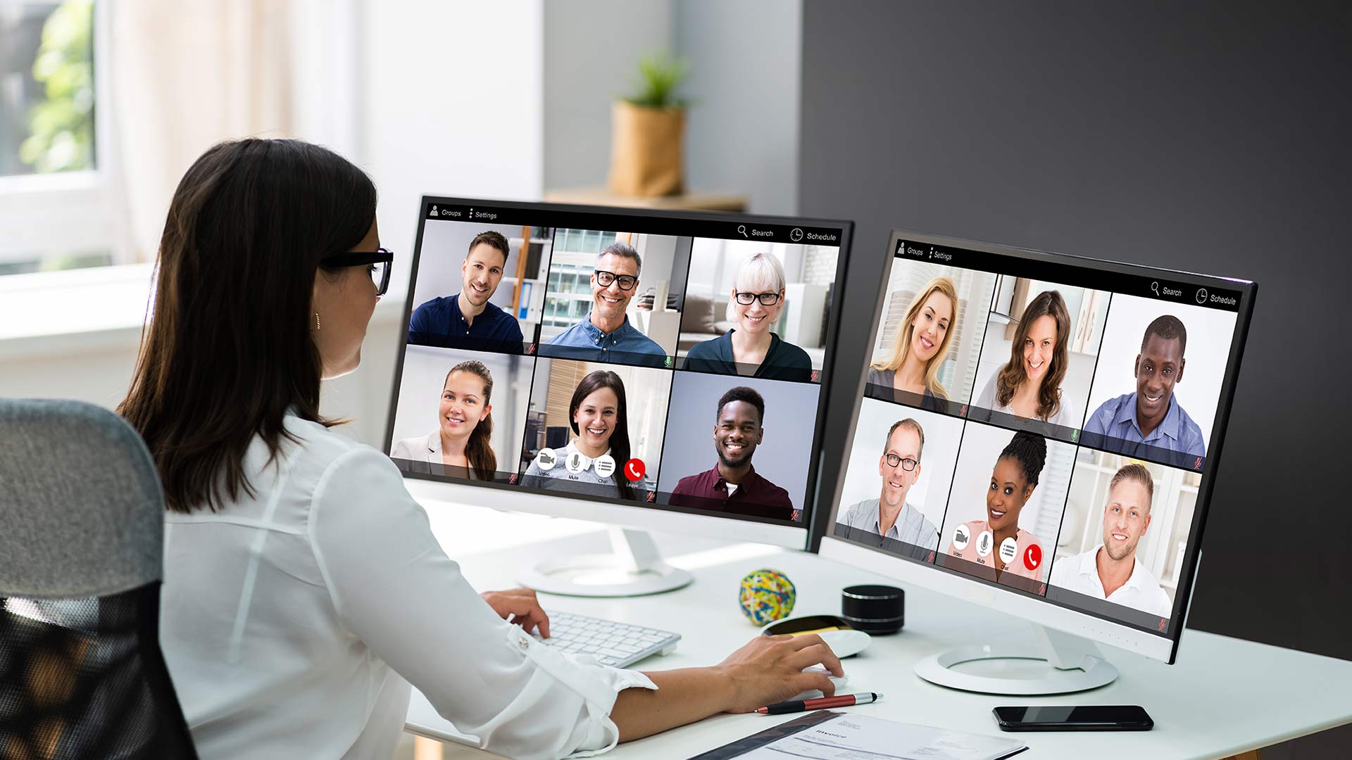 Grin Events San Diego | A woman is sitting at a desk with several monitors in front of her, engaged in remote team building.