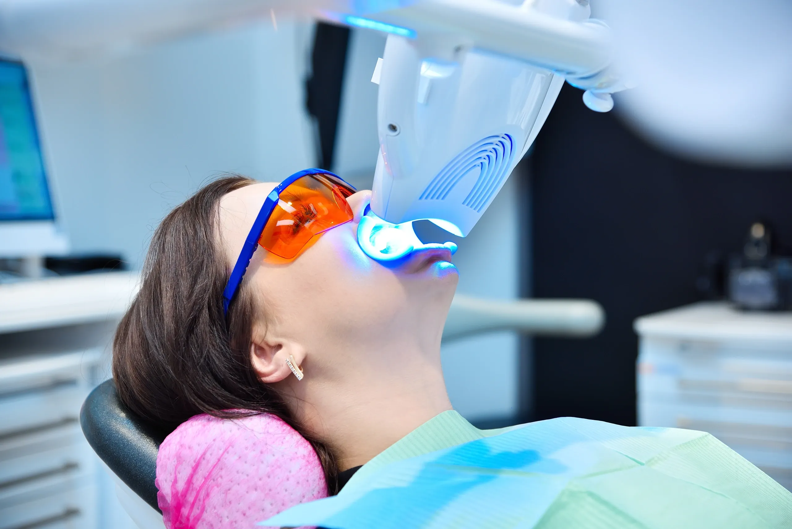photo of patient getting teeth whitened under blue light