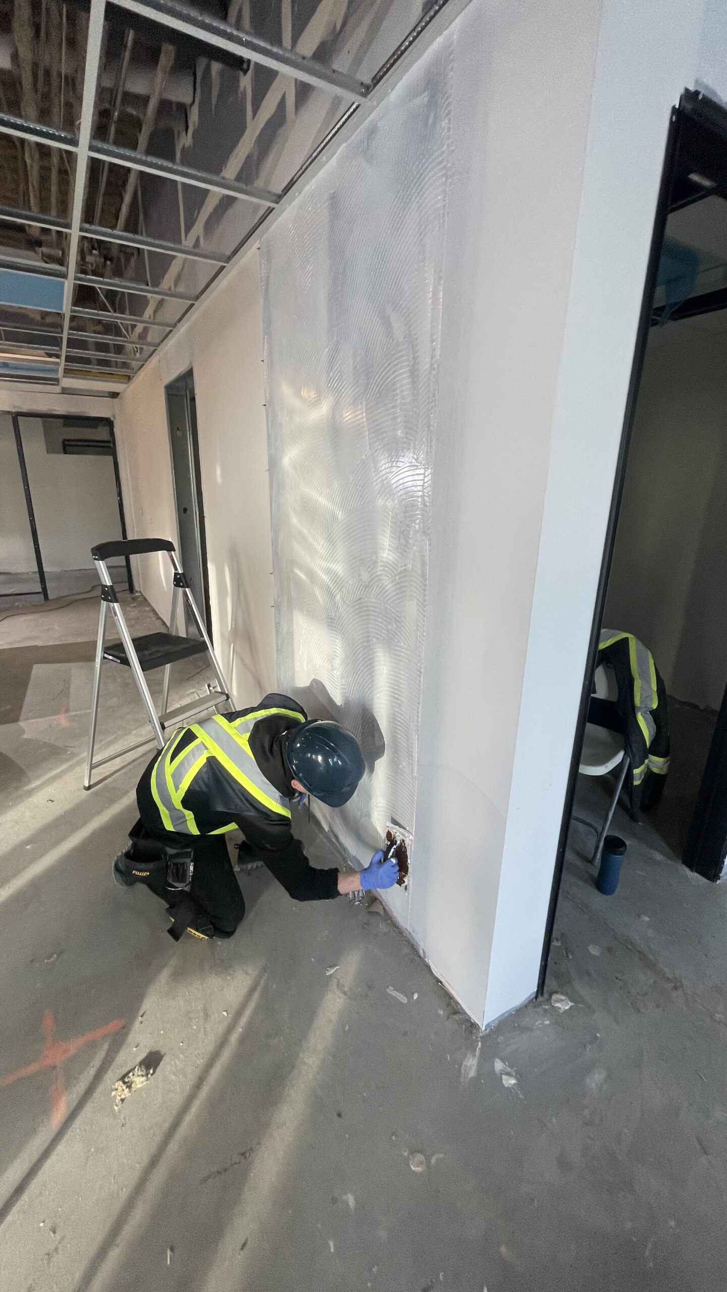 Installer fitting a full-height rigid sheet wall panel