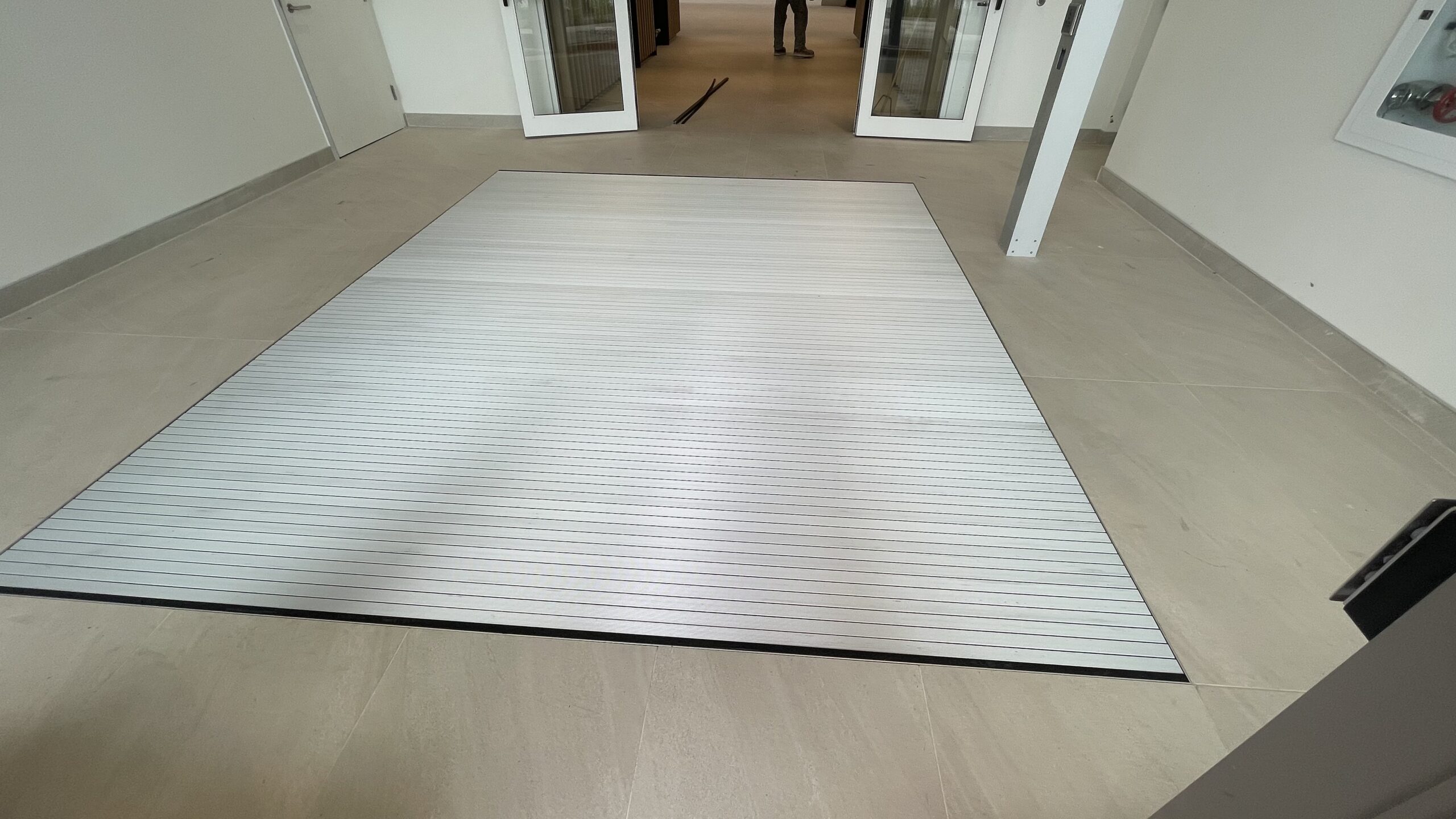 Recessed foot grille at a building entrance