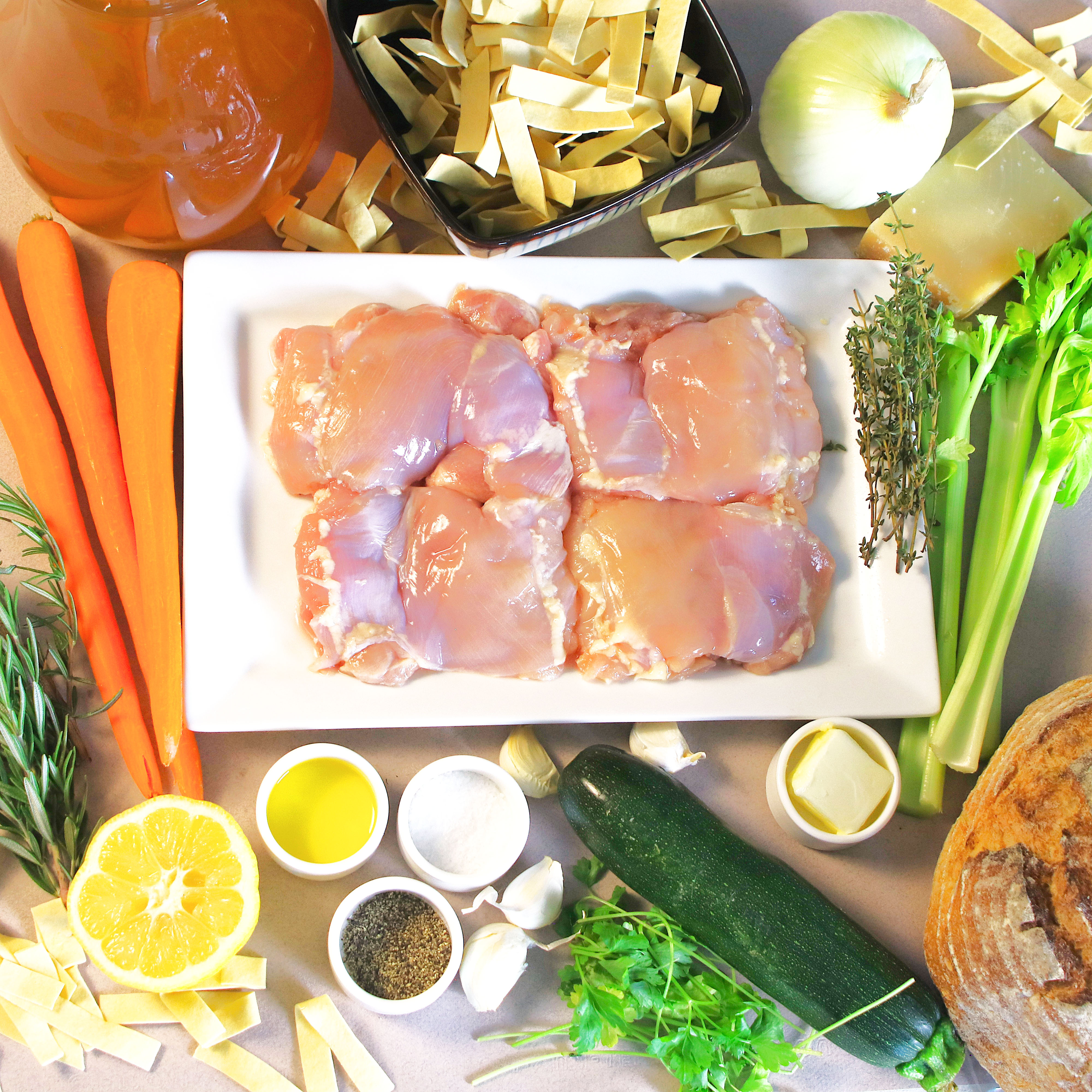 Ingredients for lemon herb chicken noodle soup: chicken, broth, egg noodles, onion, carrots, celery, zucchini, garlic, lemon, rosemary, thyme, parsley, oil, butter, salt, and pepper.