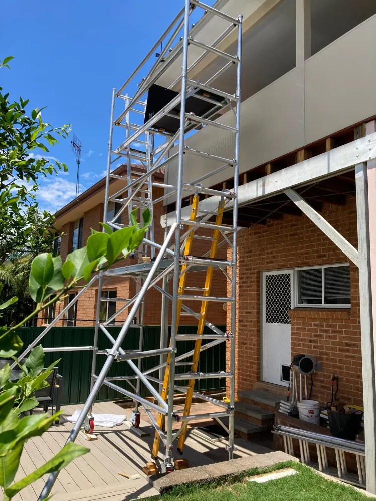 Single width mobile scaffold tower beside a house