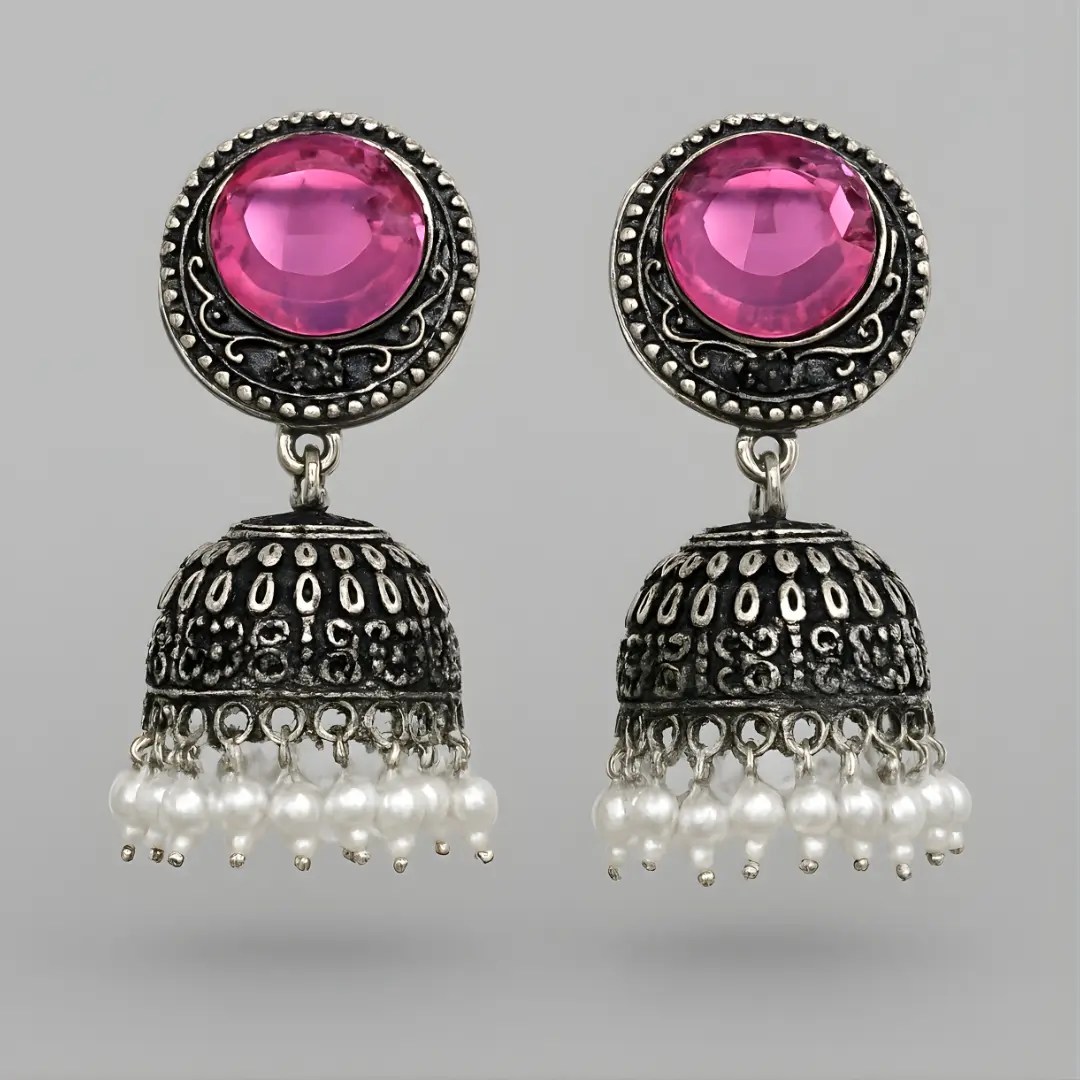 Traditional Silver Oxidised Jhumka Earrings with Pink Stone and Pearls for Women & Girls Product Highlights / Key Features Oxidised silver finish with detailed handcrafted pattern Bold round pink stone stud top Classic jhumka bell-shape design Pearl droplet hangings for an ethnic festive look Lightweight and comfortable for full-day wear Skin-friendly material Suitable for daily wear, party, wedding, festive and traditional outfits Detailed Product Description These Oxidised Silver Jhumka Earrings come with a beautifully carved traditional design and a vibrant pink stone stud top. The hanging jhumka features intricate engraved patterns and pearl drops that create a classic and elegant ethnic look. Perfect for women and girls who love Indian jewellery styles like boho jewellery, traditional earrings, temple jewellery or oxidised earrings. These earrings pair well with saree, kurti, lehenga, anarkali suits, sharara, chikankari outfits and Indo-western wear. Whether it's a wedding, college event, festival season, haldi, mehendi, Navratri Garba, or daily styling, these jhumkas complete your look instantly. Specifications Feature Details Material Alloy with Silver Oxidised Finish Top Stone Pink Glass/Cubic Stone Design Type Jhumka / Chandrika Style Closure Type Push Back Occasion Wedding, Party, Traditional, Festive, Daily Wear Weight Lightweight & comfortable SEO Keywords (High-Search Mix: English + Hinglish) silver oxidised jhumka earrings oxidised earrings for girls traditional jhumka for women pink stone jhumka earrings pearl hanging jhumka daily wear oxidised earrings ethnic earrings for women wedding jhumka earrings boho jhumka earrings oxidised jewellery for girls jhumki earrings design navratri jhumka earrings college wear earrings girls silver jhumka for lehenga oxidised bali earrings traditional jewellery india ladies jhumke online ethnic earrings for kurti party wear jhumka affordable jhumka earrings