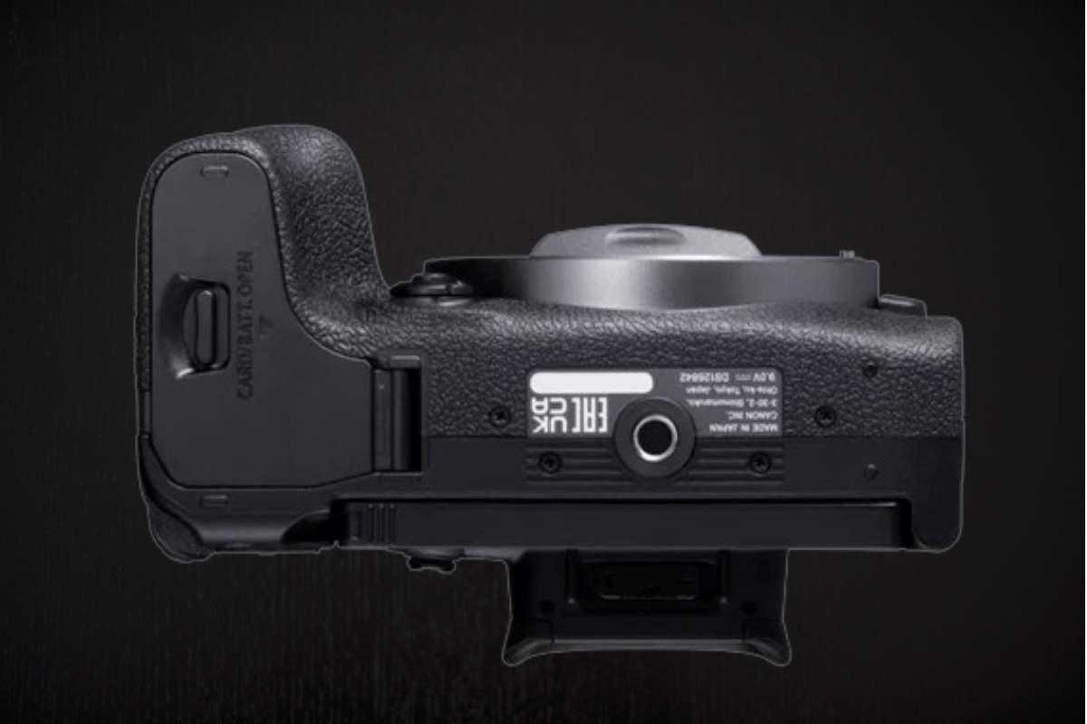 المنظر السفلي لكاميرا Canon EOS R10 يظهر منفذ الحامل الثلاثي ومنافذ التوصيل، مما يعكس التصميم العملي والهندسي المخصص لتوفير سهولة الاستخدام والاستقرار أثناء التصوير.