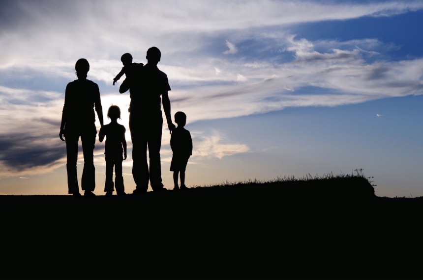 A family in shadow looking at the sky