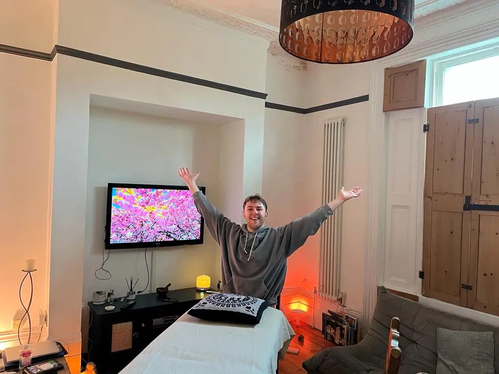 Brandon stands over a massage table
