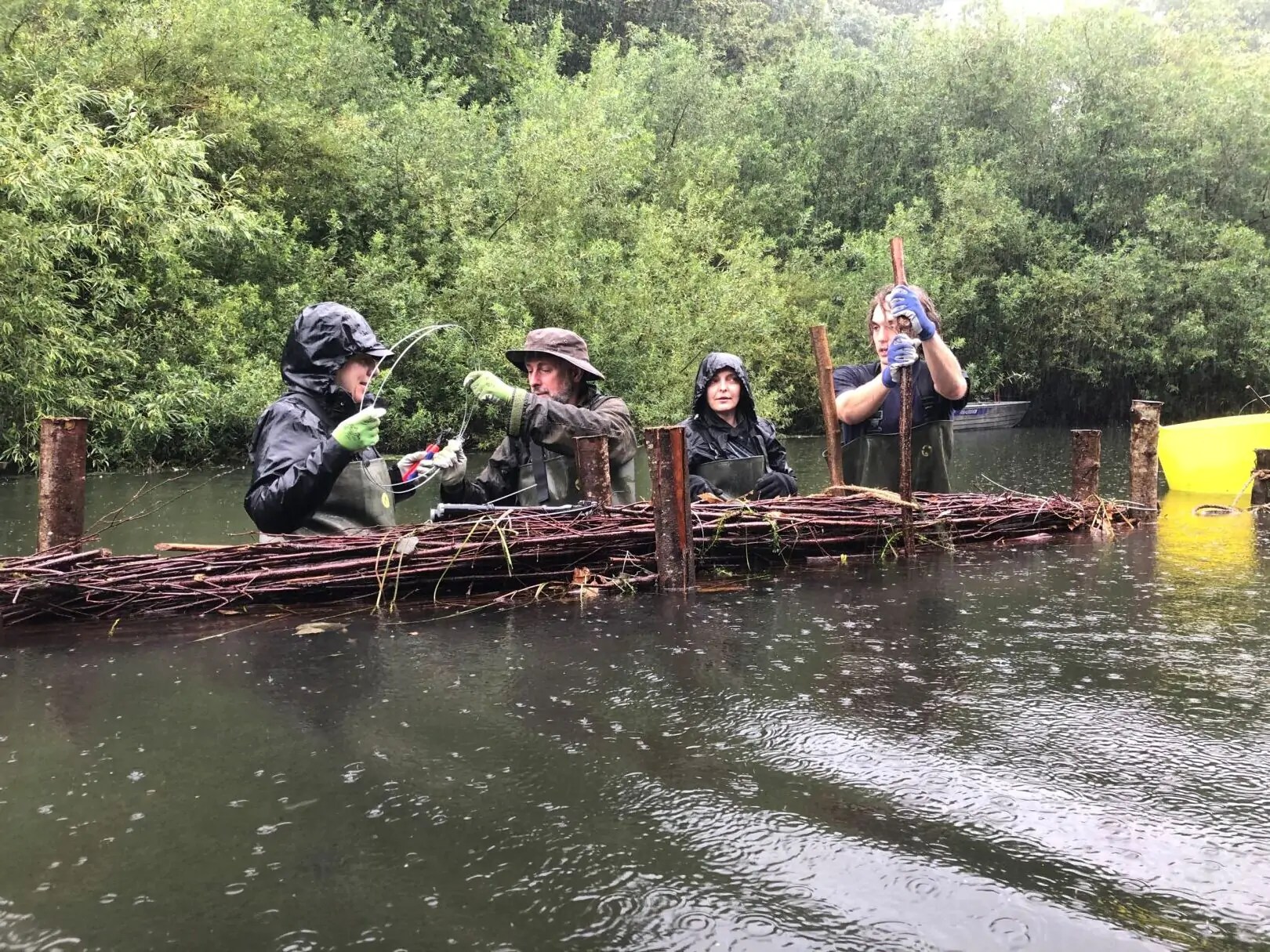 Gardeners work on a wooden dam