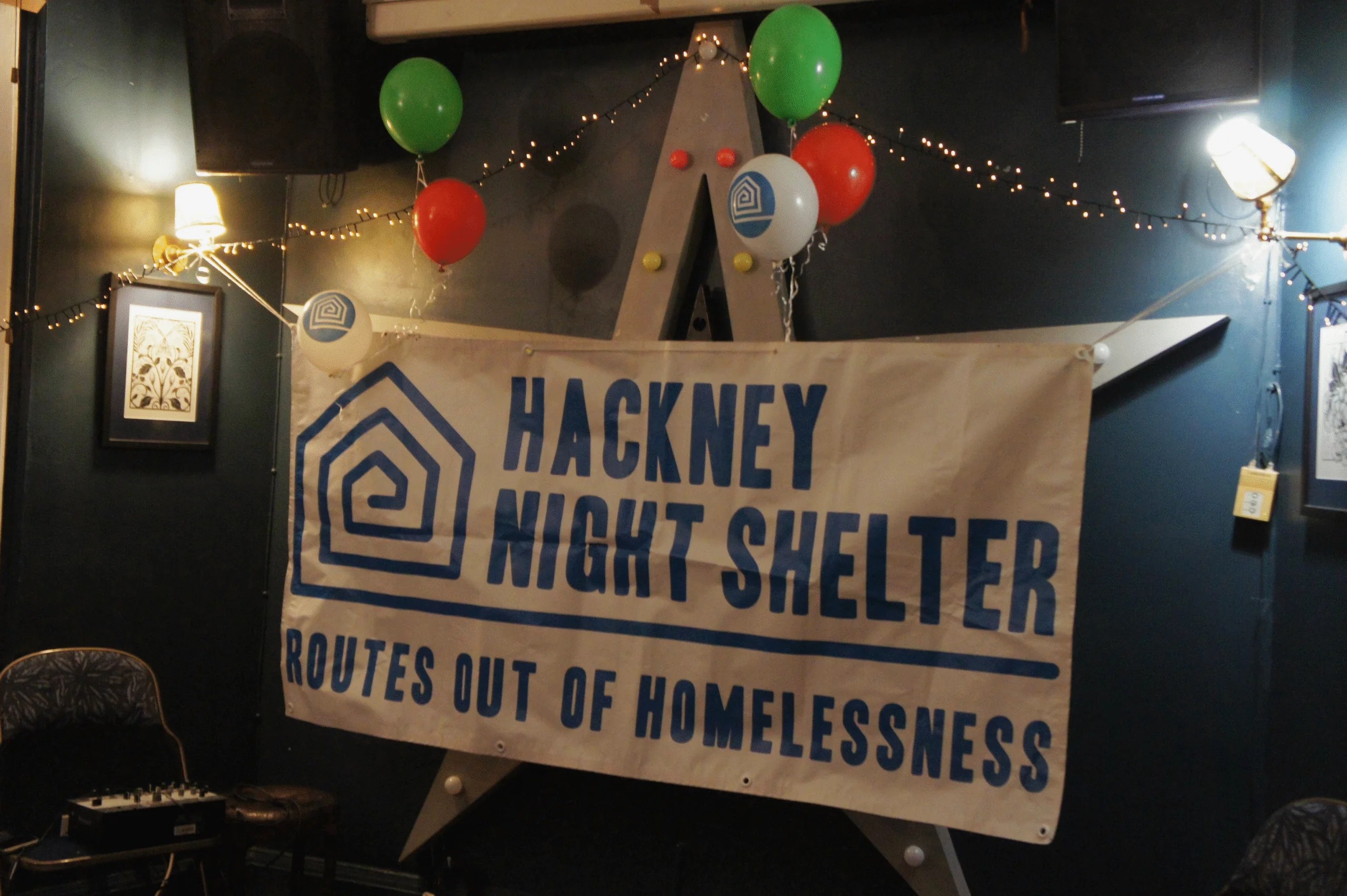 Banner showing Hackney Night Shelter banner at the Christmas Card launch saying "Hackney Night Shelter - Routes out of homelessness"