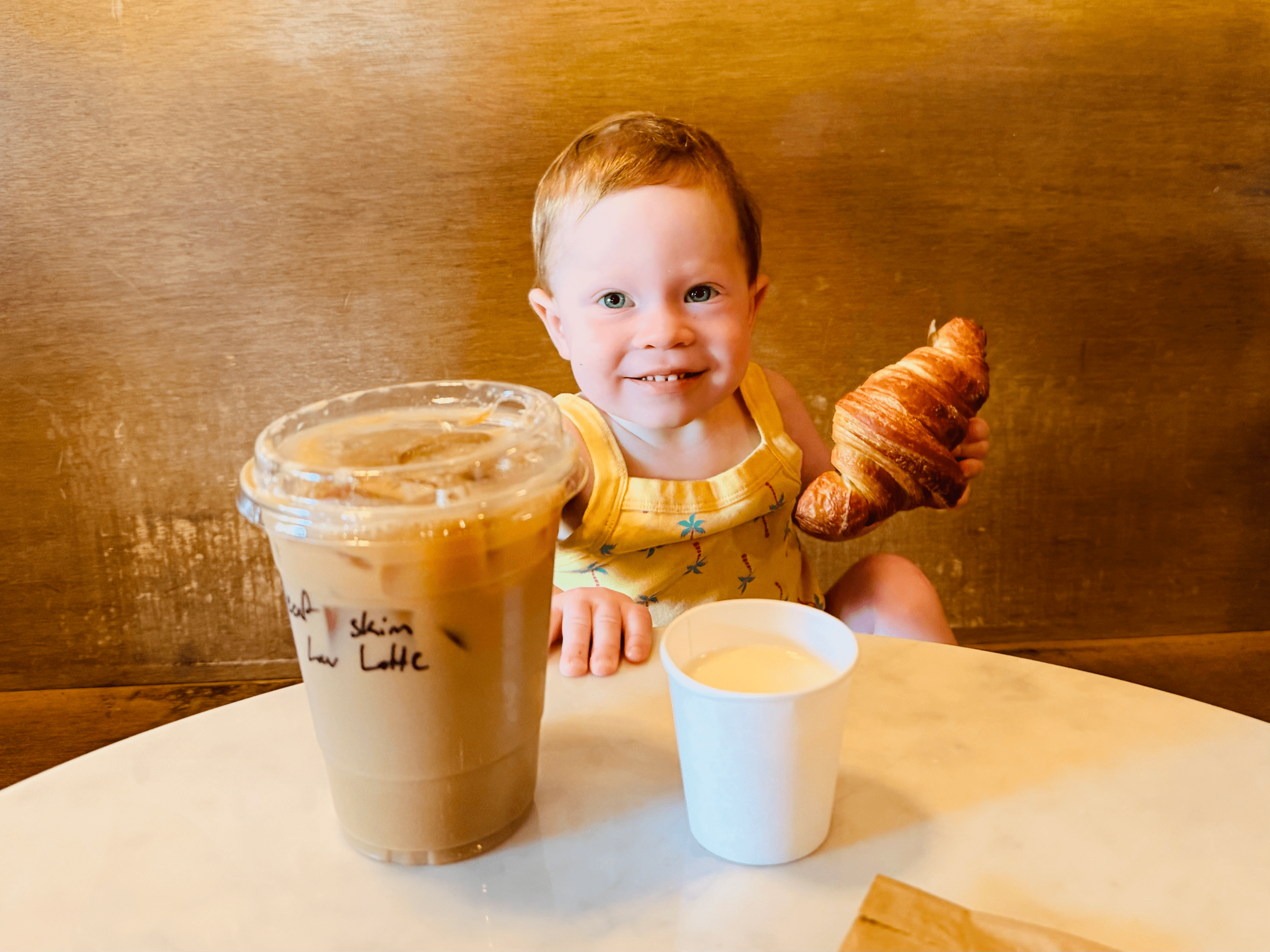 Baby with coffee and croissant