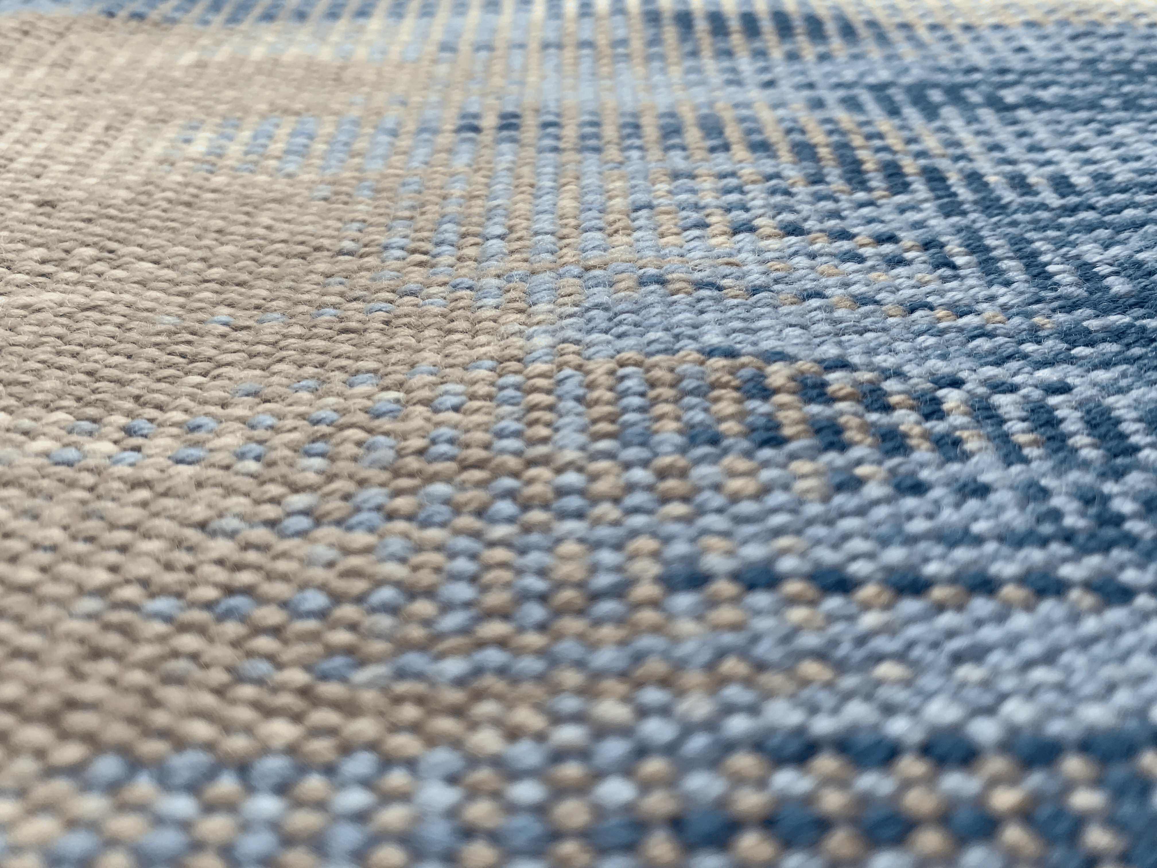 Detail shot of handwoven textile in blue, tan and white.