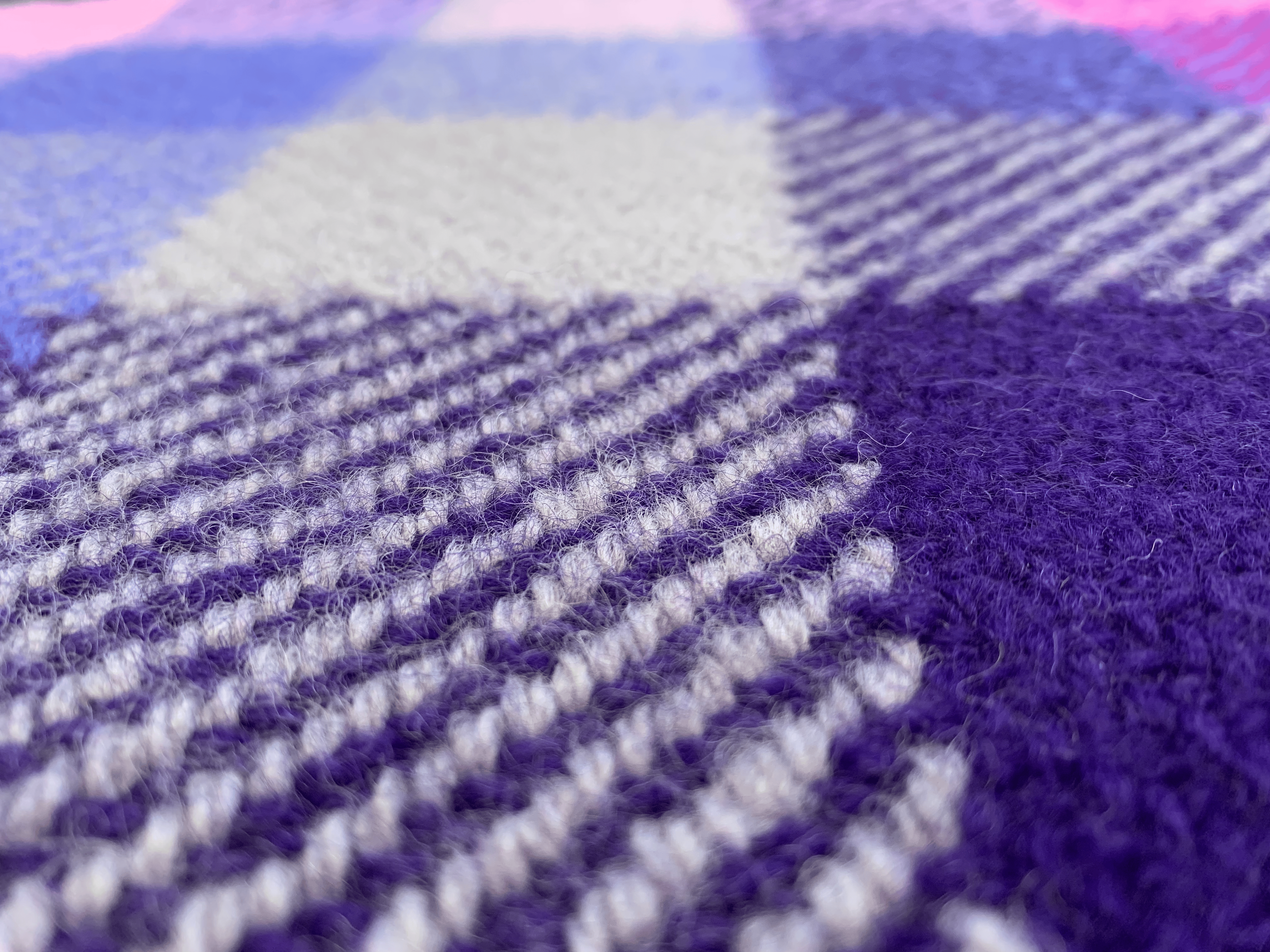 A close-up detail shot of a twill blanket in shades of purple and grey.