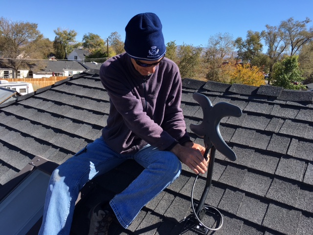 Installing a TV antenna on a roof.