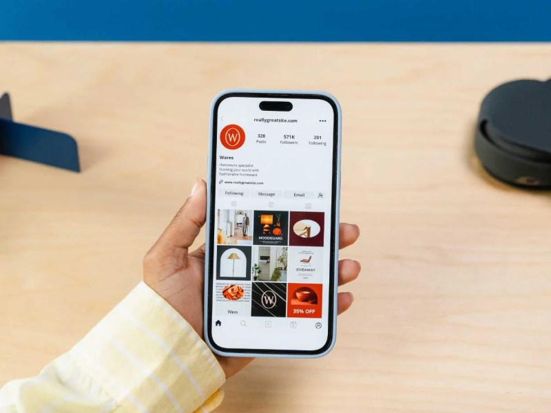 Individual holding an iPhone that shows an example instagram feed.
