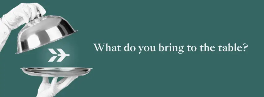 A hand lifts a cloche to reveal a serving tray below, unveiling Hardly’s logo, alongside the text “What do you bring to the table?”
