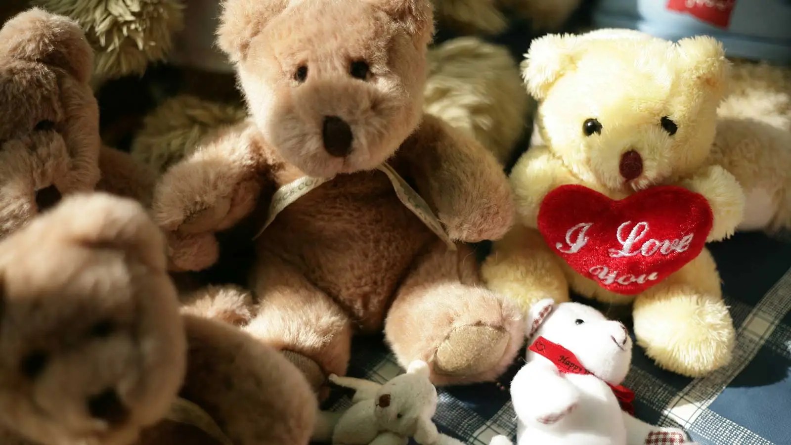 pile of teddy bears with hearts, ribbons, and bows