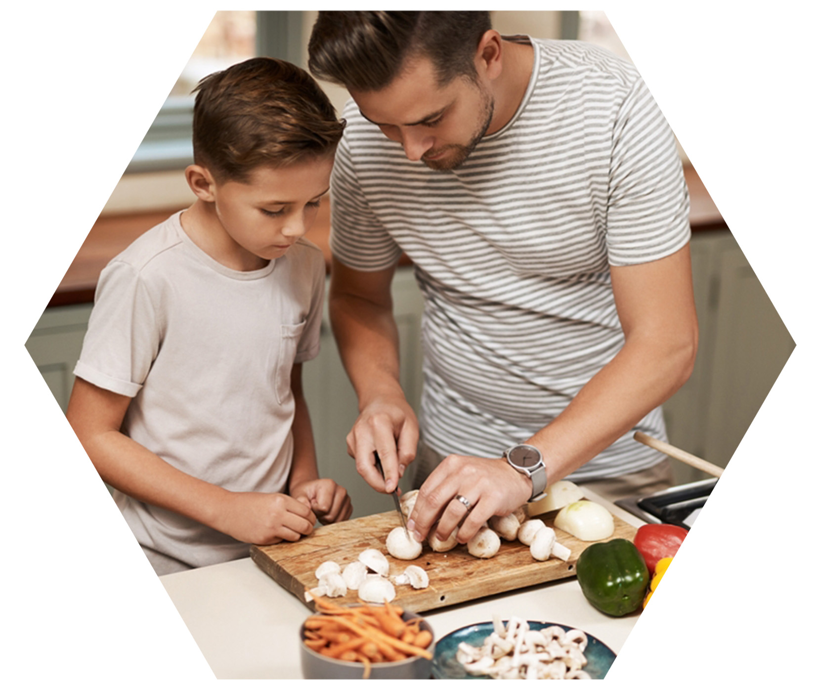 Father showing son wellness basics as they cook clean food together in the kitchen.