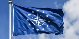 NAVO-topmilitair ziet Europa gaten vullen bij minder Amerikaanse steun. Een bijeenkomst van NAVO-leiders met de vlaggen van de lidstaten op de achtergrond.